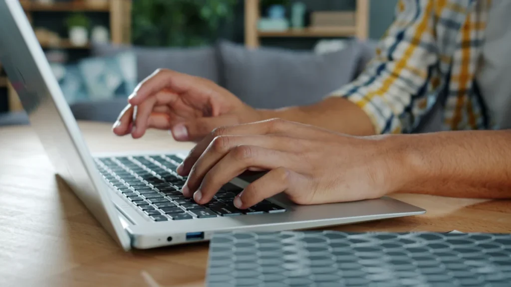 AI Writing Tools Compared: 10 Options, Features and Pricing 1 Person typing on a laptop while comparing AI writing tools