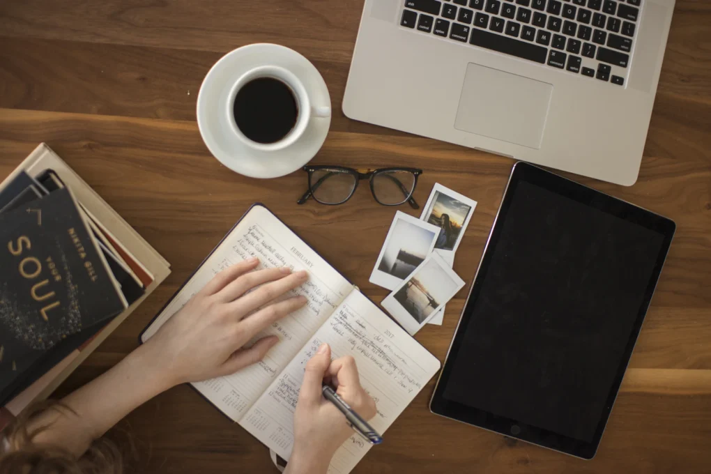 AI Writing Tools Compared: 10 Options, Features and Pricing 2 Open notebook and laptop on a desk, ready for planning