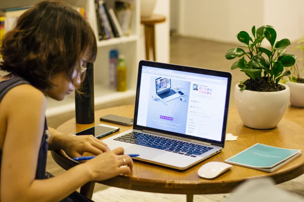 Person comparing digital tools for creators on a laptop in a bright room