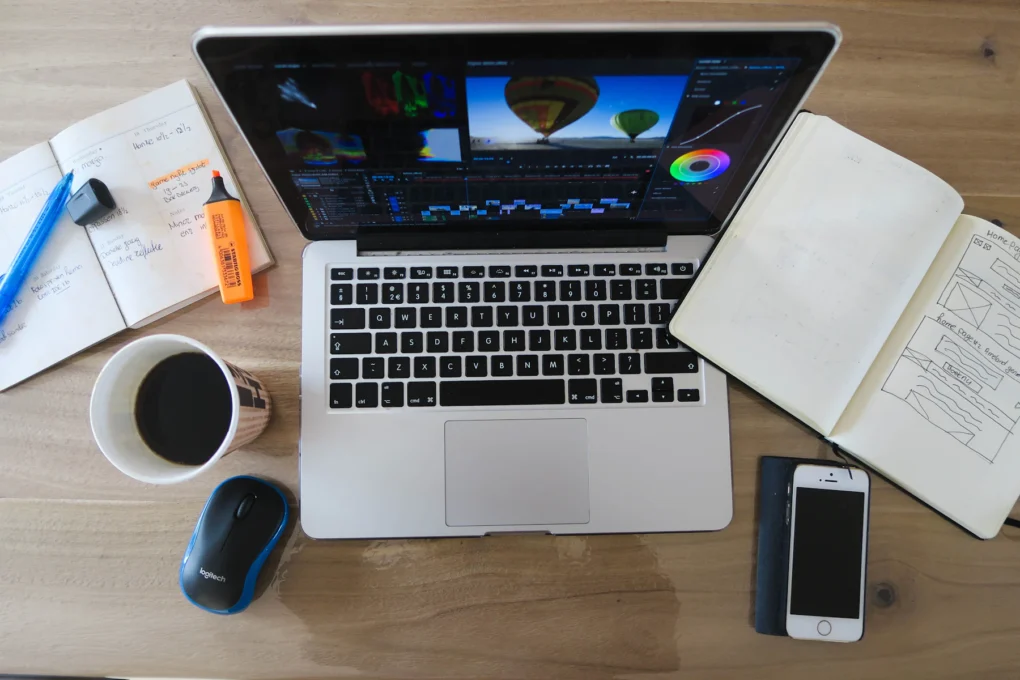 Digital tools for creators on a desk: laptop, notebook and smartphone