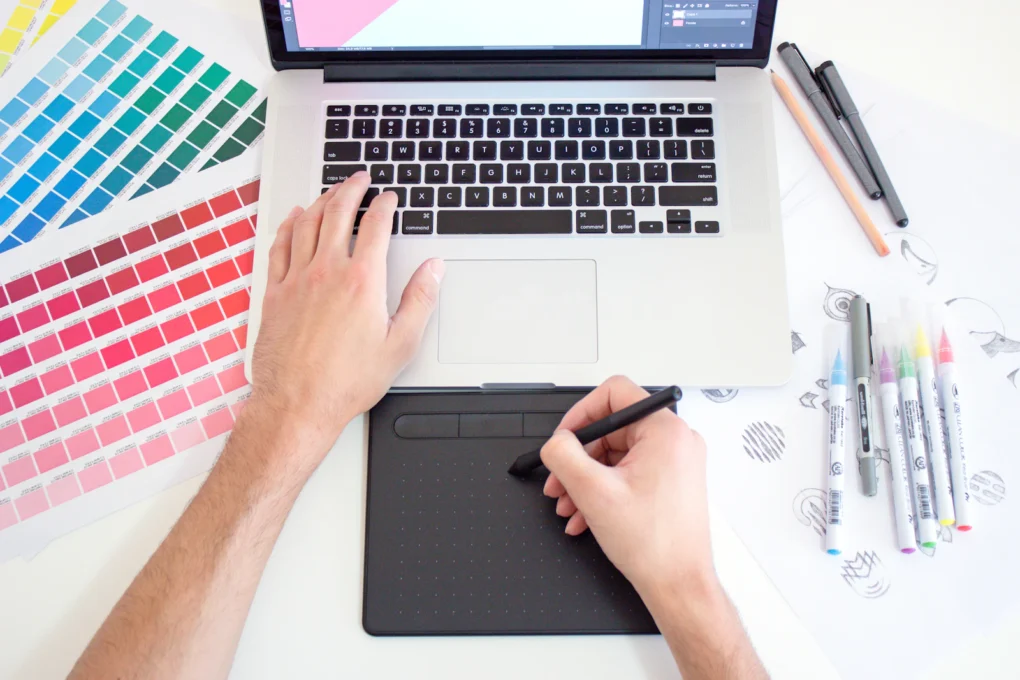 Designer using a pen tablet next to color swatches