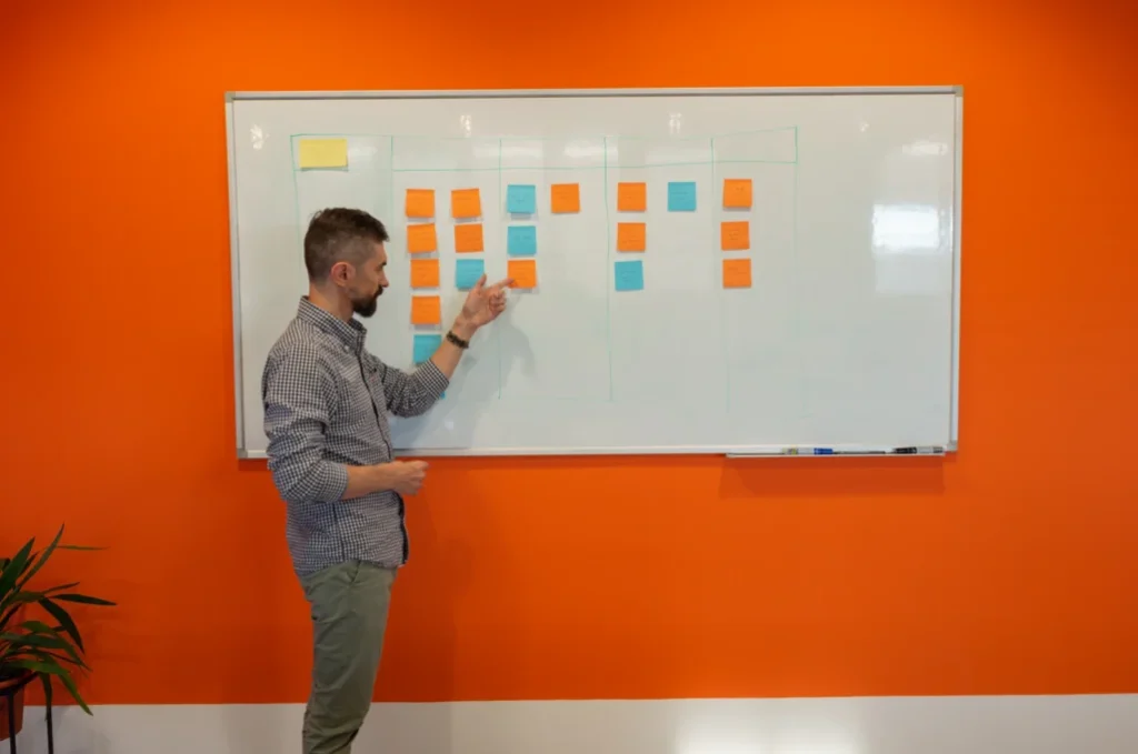Person organizing sticky notes on a task board