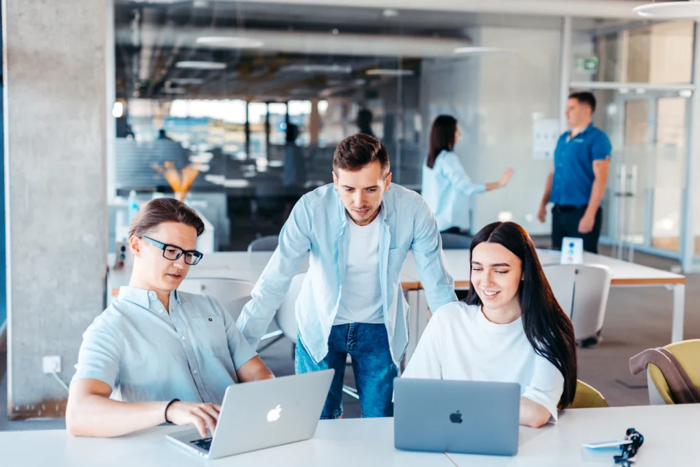 Small team working together with laptops at a table