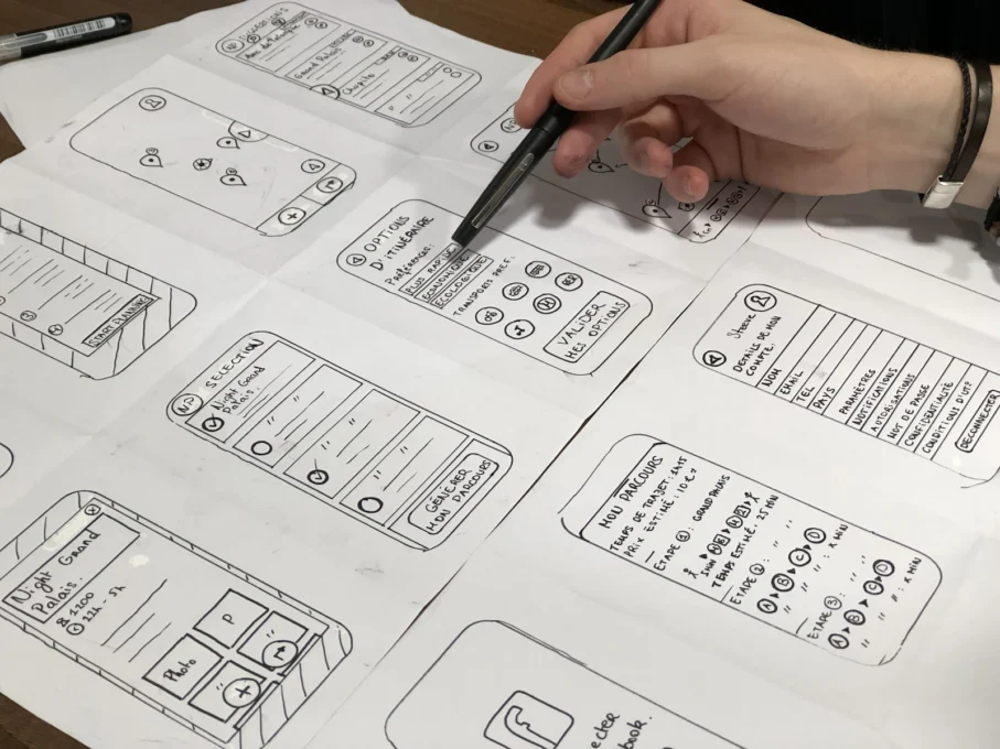 Hand sketching mobile app wireframes on paper