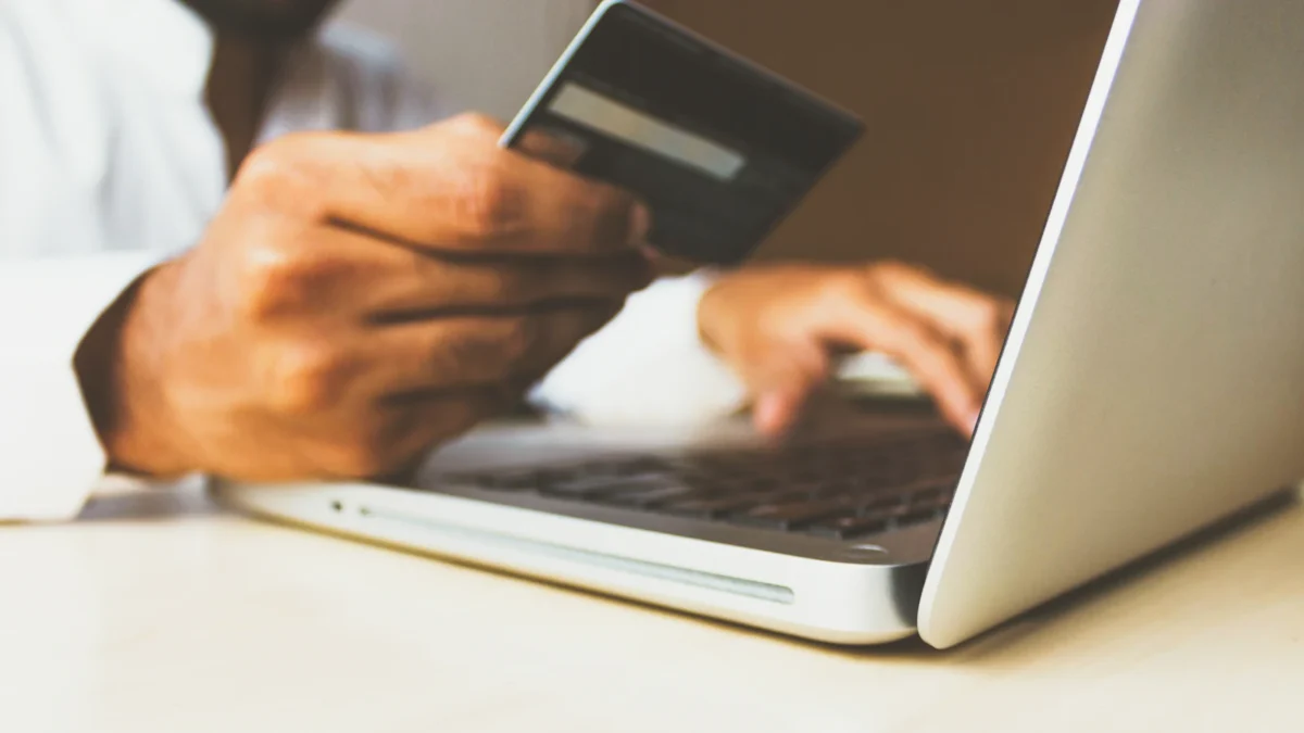Checkout Tools Compared: ThriveCart, SamCart and PayKickstart 2 Person holding a credit card while paying on a laptop checkout page