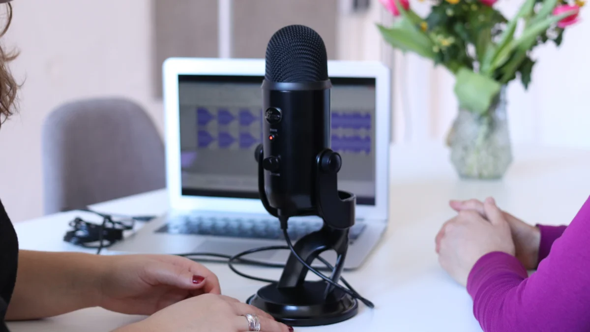 Microphone and laptop on a desk set up to host a webinar